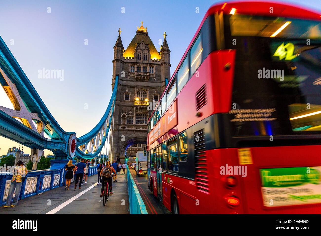Red double decker bus crossing Tower Bridge at night, London, UK Stock Photo