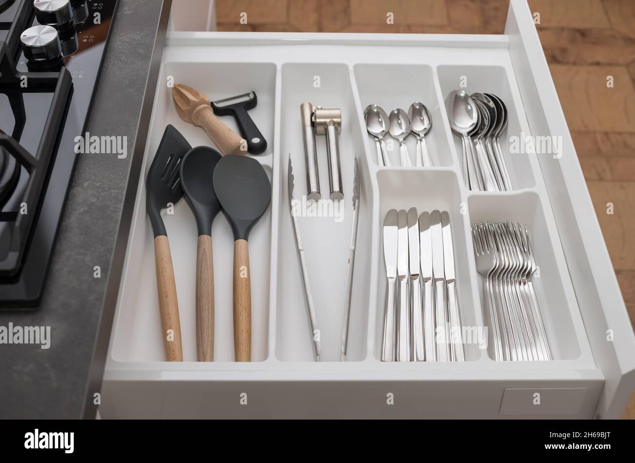 Inside of kitchen opened drawer with utensils and cutlery Stock Photo
