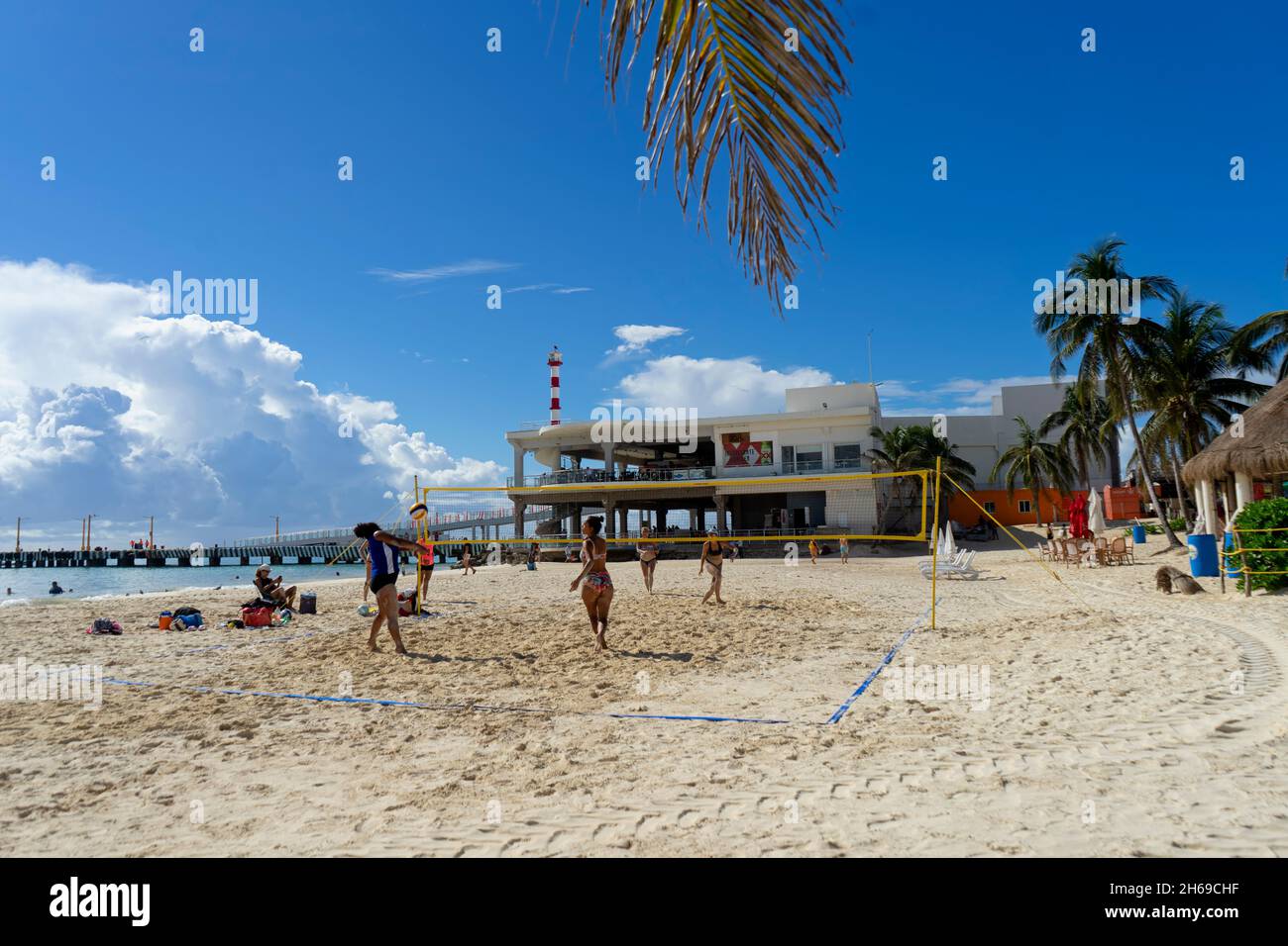 Mexican girls play beach volleyball during their free time on a sunny day at a Caribbean beach. Stock Photo