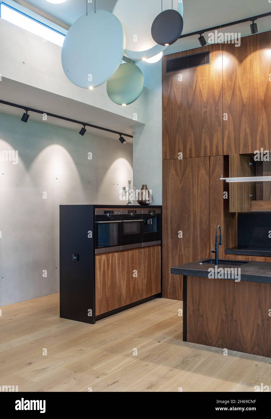 Modern interior of wooden kitchen with sink and black counter. Built-in ...