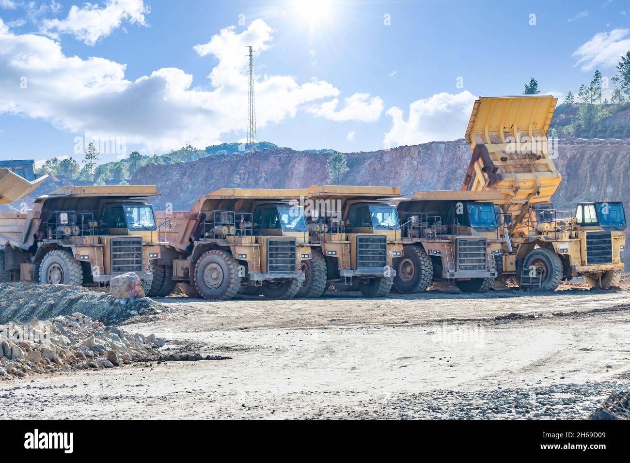 Mining trucks and machinery in Corta Atalaya open mine pit. Deep excavation of pyrite and extraction of minerals of cooper and gold in municipality of Stock Photo