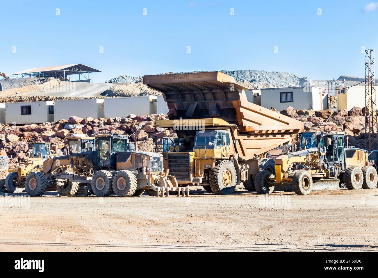 Mining trucks and machinery in Corta Atalaya open mine pit. Deep excavation of pyrite and extraction of minerals of cooper and gold in municipality of Stock Photo