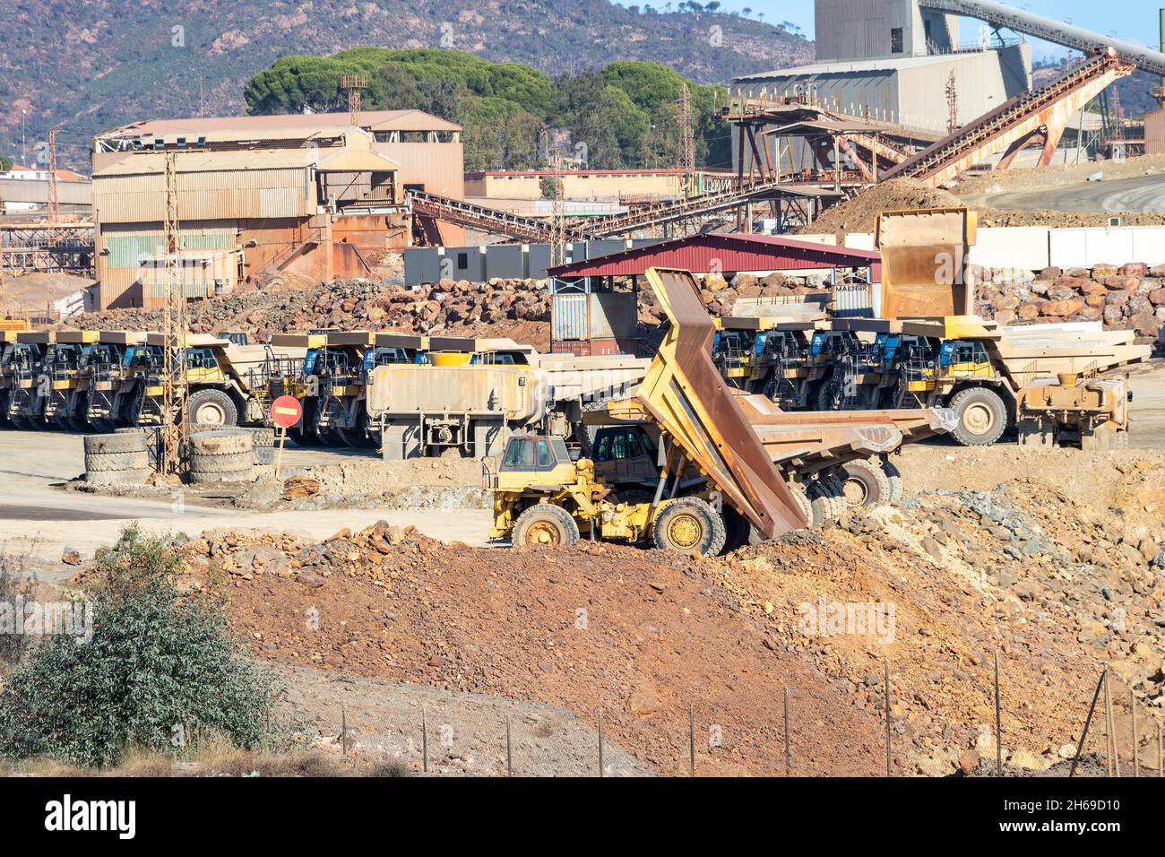 Mining trucks and machinery in Corta Atalaya open mine pit. Deep excavation of pyrite and extraction of minerals of cooper and gold in municipality of Stock Photo