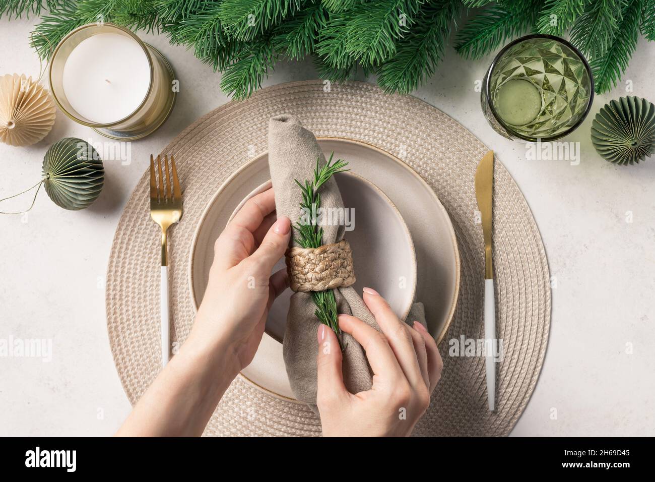 Woman preparing festive place setting for Christmas dinner Stock Photo