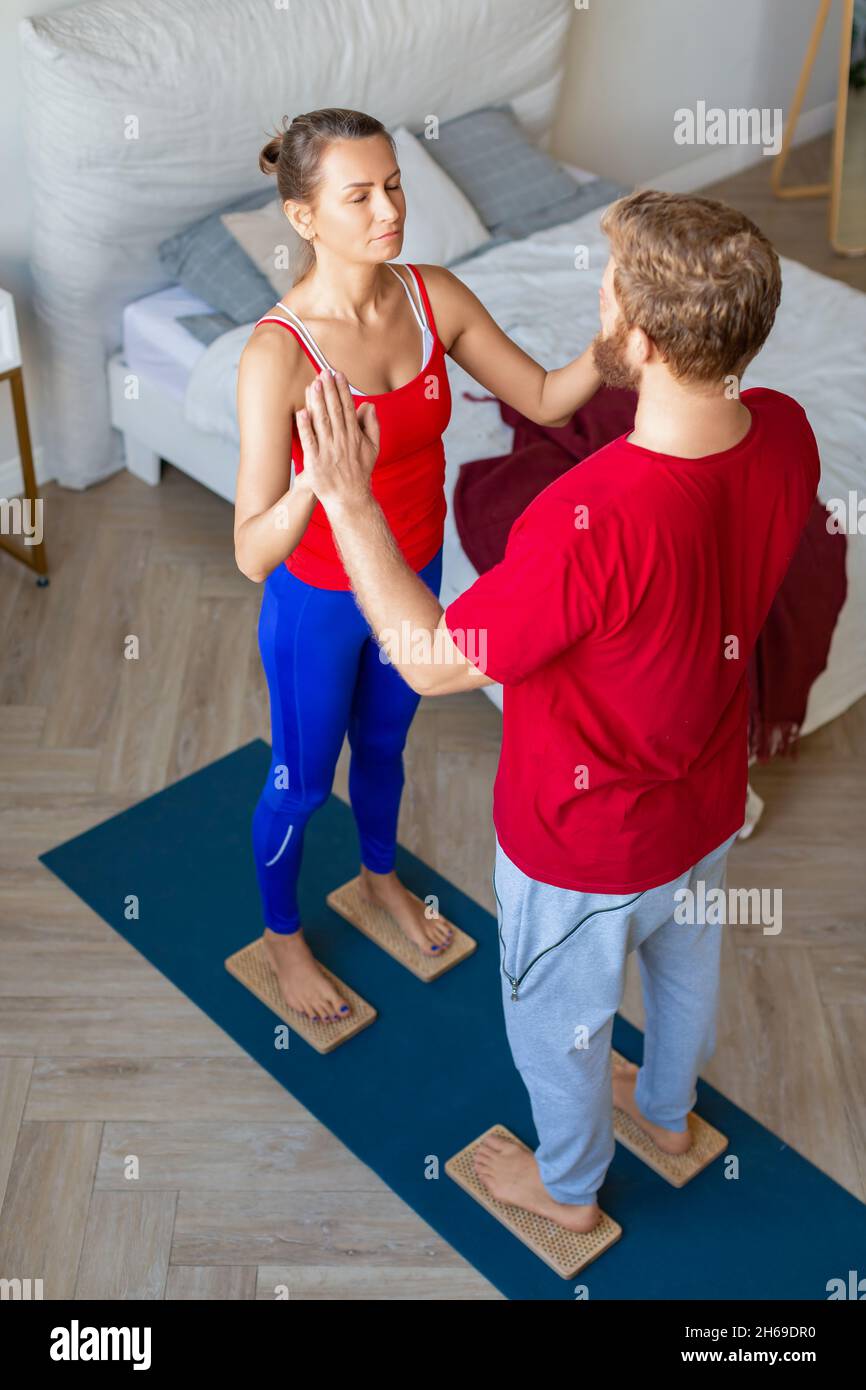Couple standing on Sahu boards with sharp nails. Yoga practice and meditation together. Stock Photo