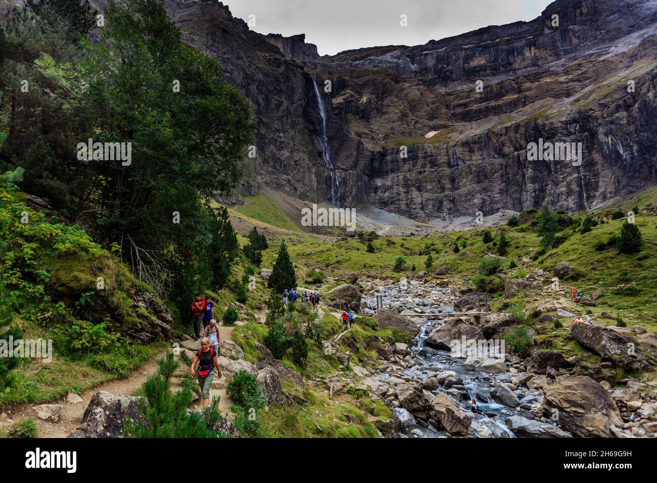 Hikers walk in the Cirque de Gavarnie in the French Pyrenees National ...