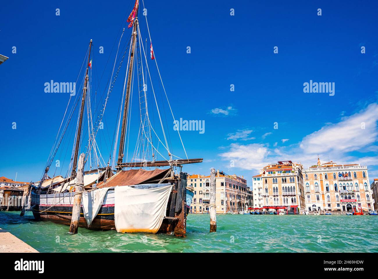 Ancient sailing ship moored on grand canal with buildings in background Stock Photo