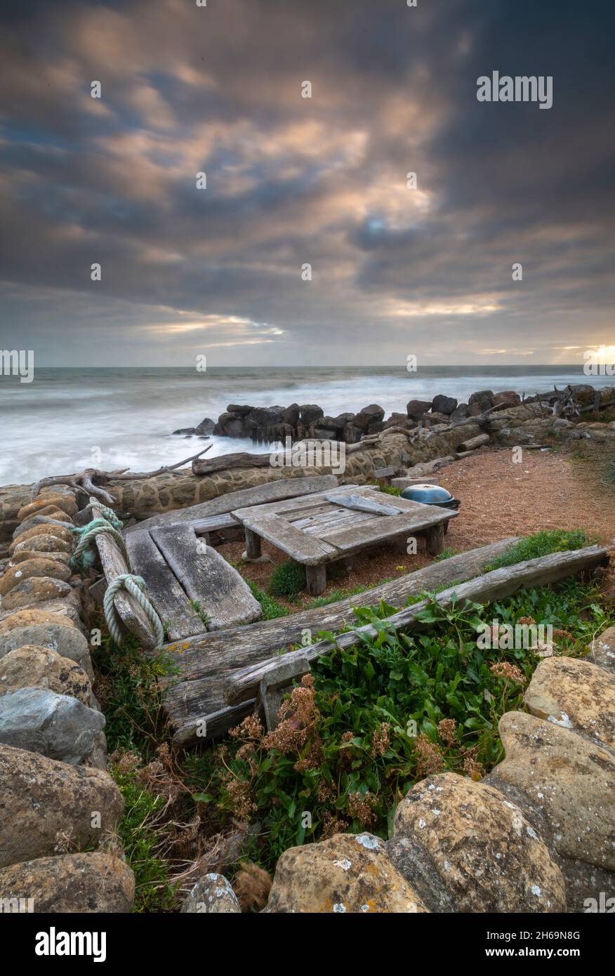 outdoor dining and barbeque area made from driftwood furniture on the