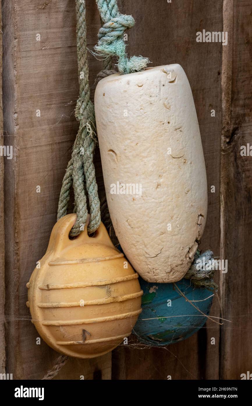old discarded fishing trawler floats and buoys hanging on the side of a  beach hut on the isle of wight as decoration. flotsam and jetsam, fishing  buoy Stock Photo - Alamy