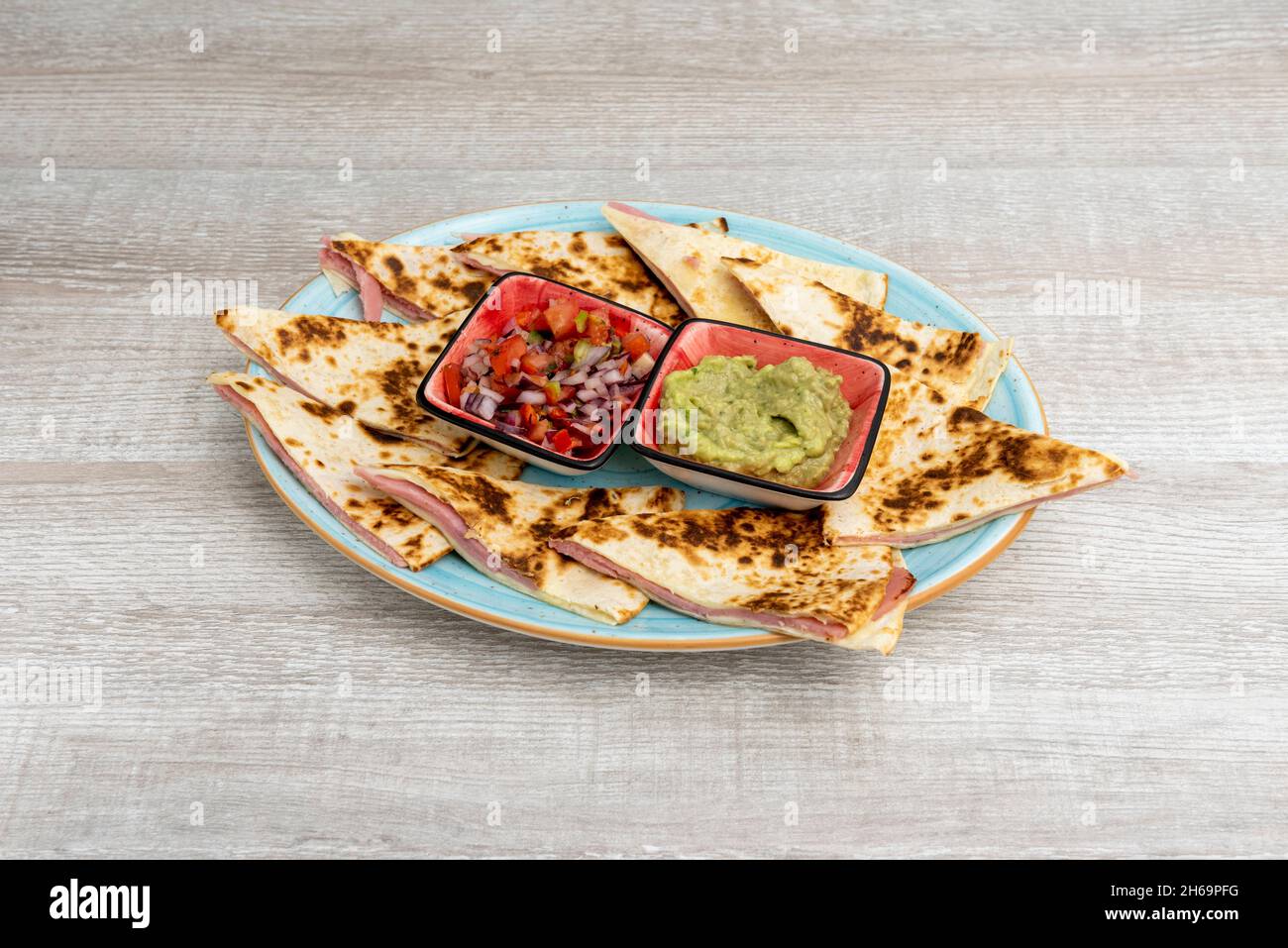 The quesadilla consists of a corn or wheat tortilla, folded in half that can be filled with cheese or other ingredients and eaten hot, either fried or Stock Photo