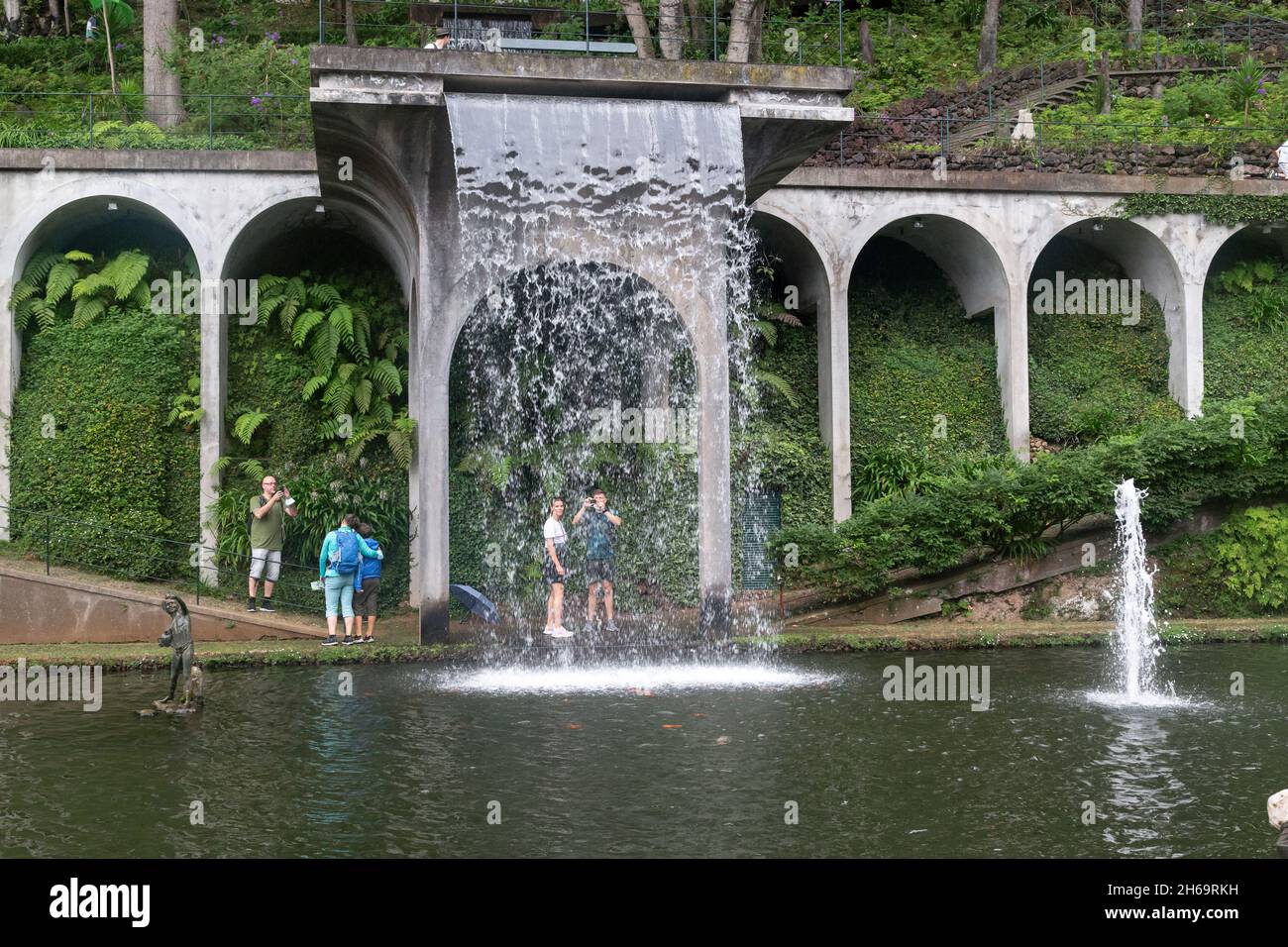 FUNCHAL, PORTUGAL - AUGUST 24, 2021: These are unidentified people near artificial waterfall of the central lake in Monte Tropical Park. Stock Photo