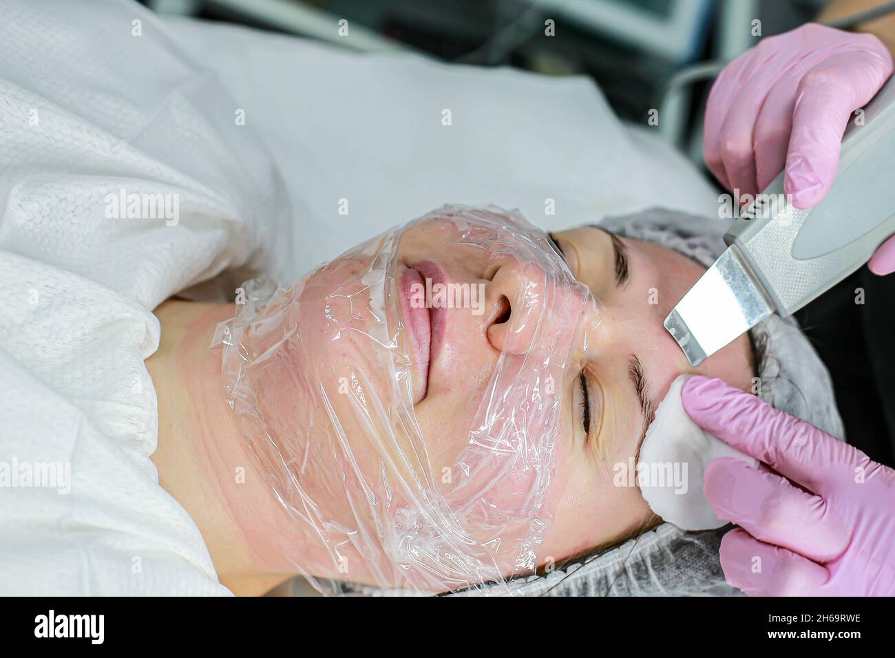 Cosmetologist girl does ultrasonic cleaning of the face Stock Photo