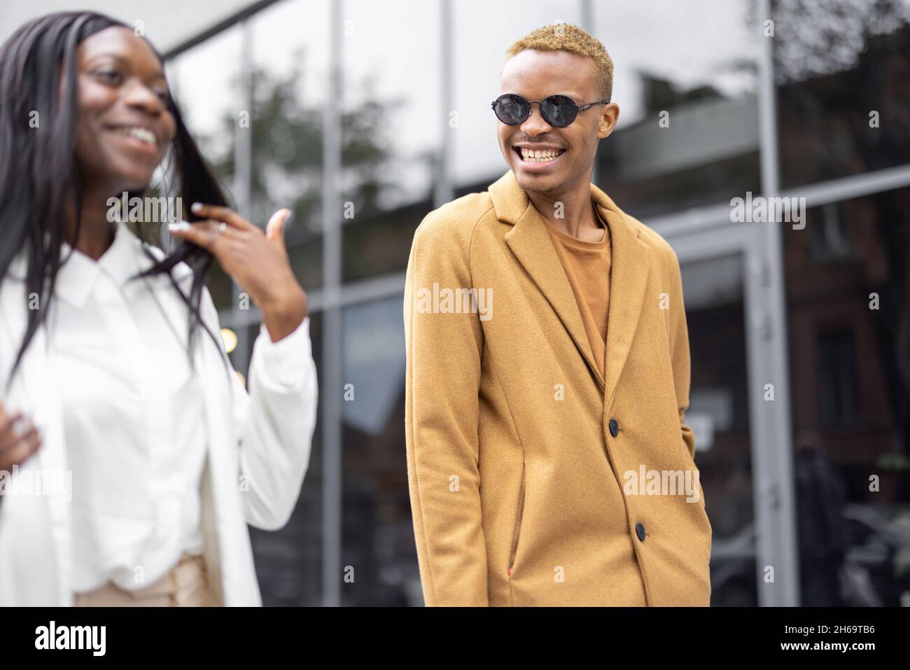 Man and woman walking on city street and talking Stock Photo - Alamy