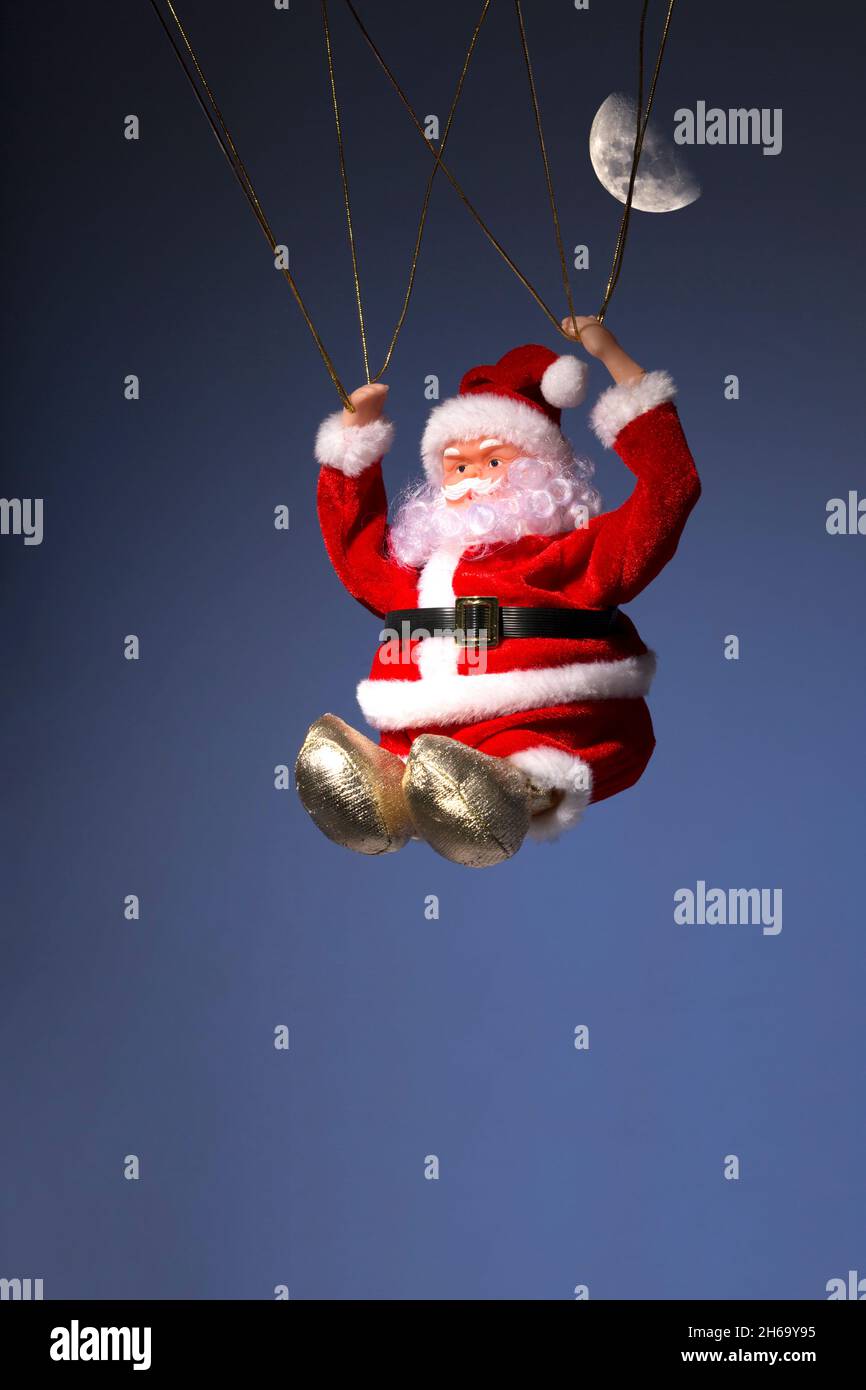 Santa Claus Father Christmas Parachuting in Night Sky with Moon Stock Photo