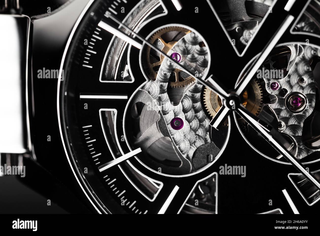 Swiss mechanical skeleton wrist watch, black deal and hands. Close-up photo. It is a watch type in which all of the moving parts are visible Stock Photo