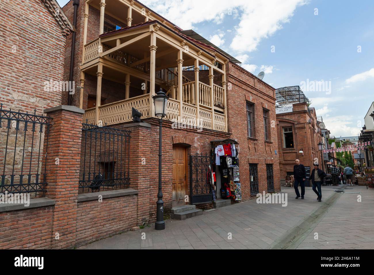 Tbilisi, Georgia - April 28, 2019: Old Tbilisi street view with traditional wooden balconies, ordinary people walk the street Stock Photo