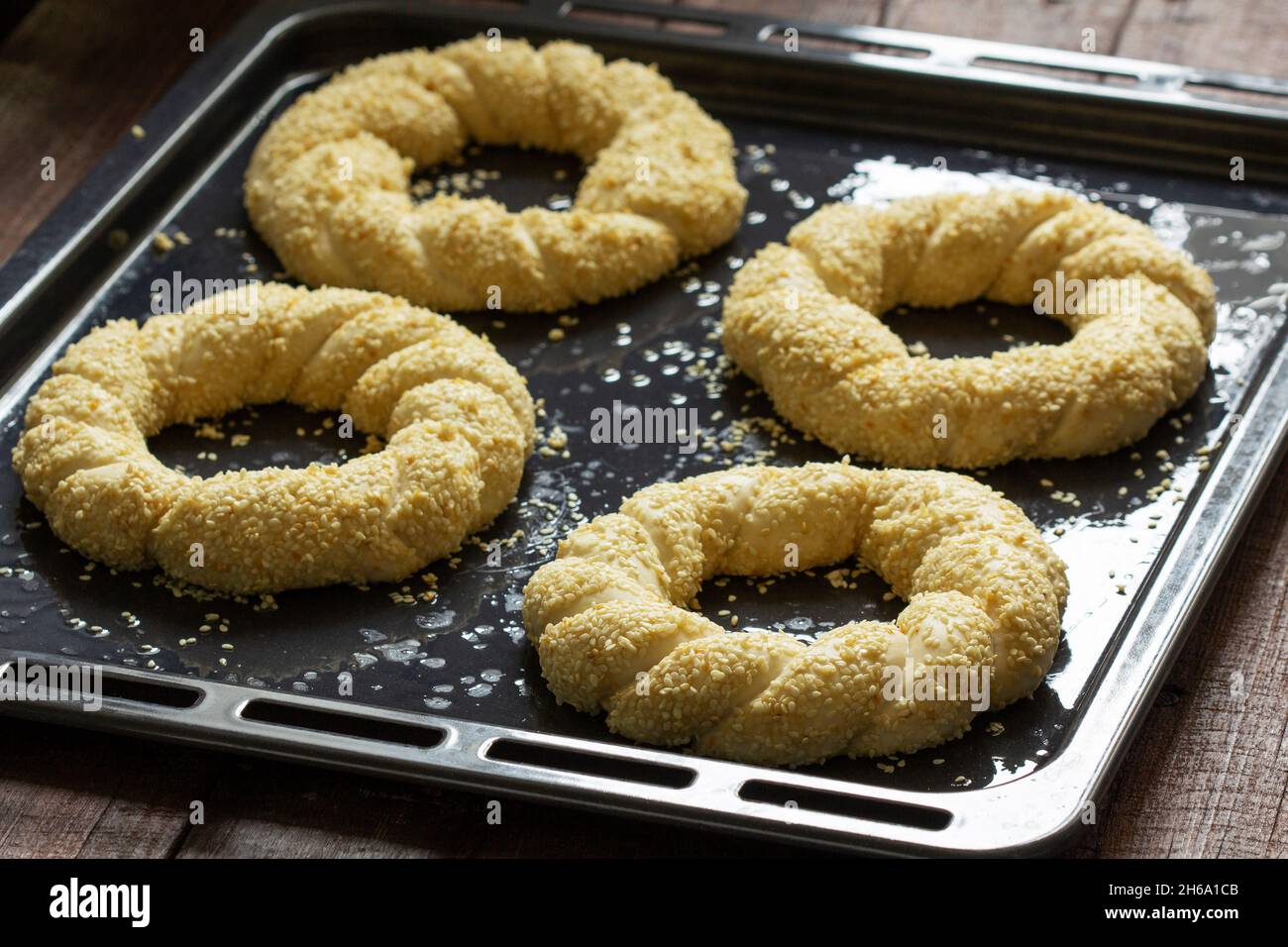 Traditional Turkish sesame simits prepared for baking. Rustic style. Stock Photo