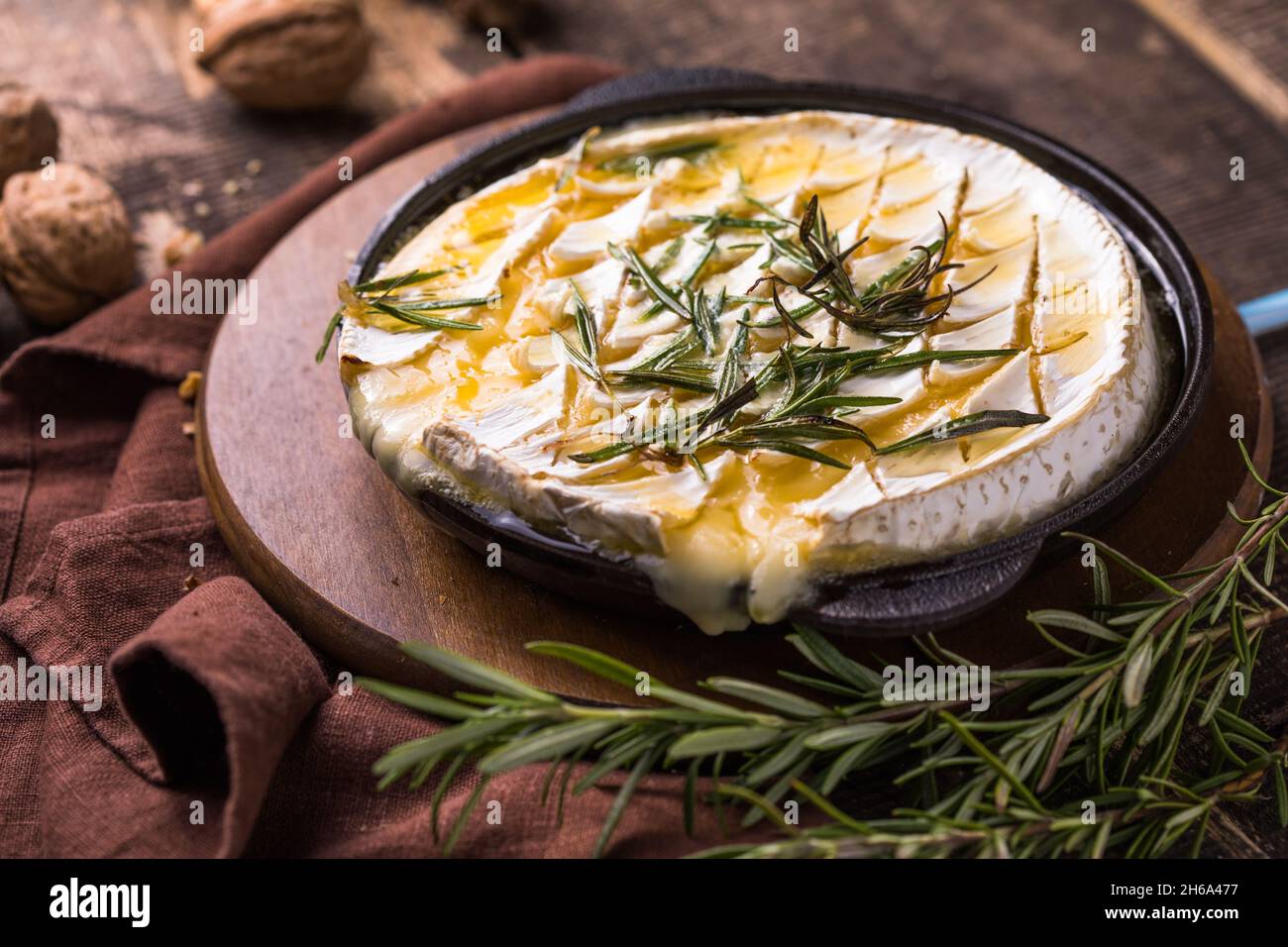 roasted Camembert or Brie with rosemary, honey, nuts Stock Photo