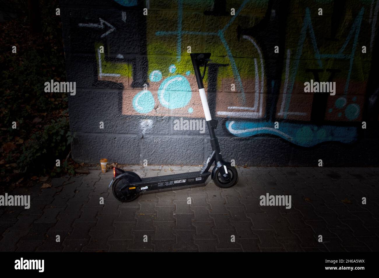 Leih E-Scooter achtlos an einer Graffiti Wand abgestellt. Stock Photo