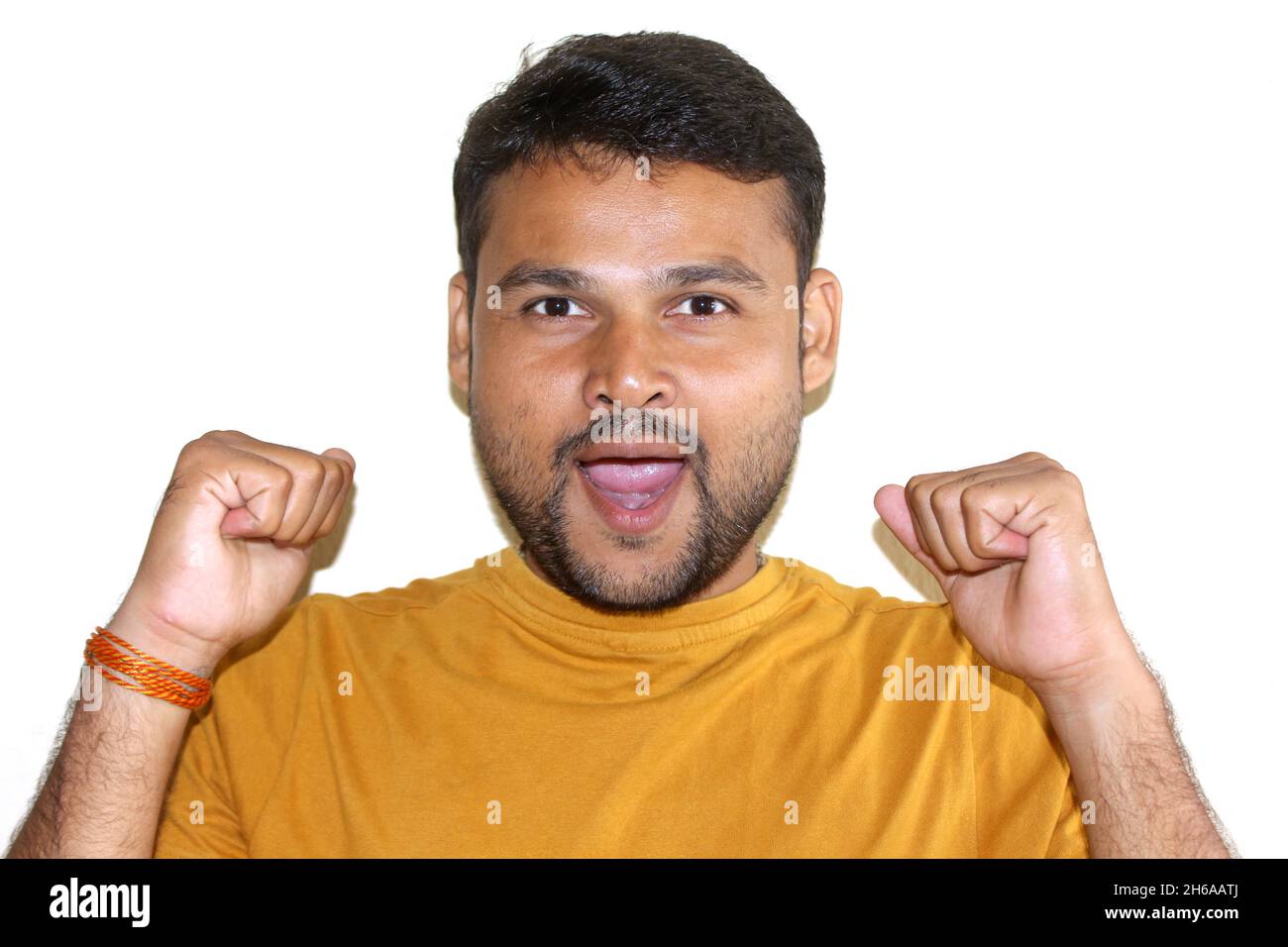 Portrait of cheerful attractive Asian male being excited and glad to achieve victory, clenches fists, screms in positivity, being real champion and su Stock Photo