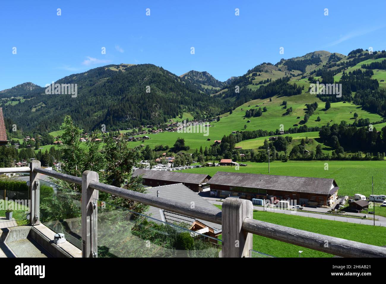 A hillside range in Zweisimmen, Switzerland. Stunning sloping countryside with a near perfectly clear blue sky. Stock Photo