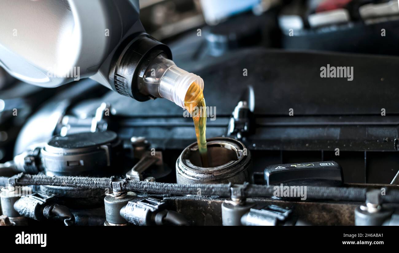 Pouring synthetic motor oil in diesel engine. Stock Photo