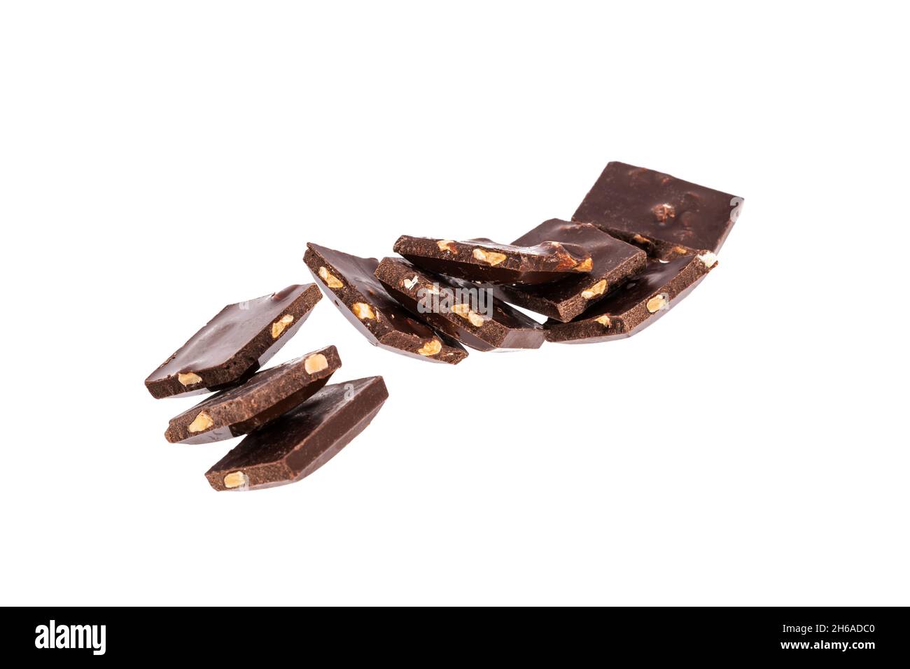 pieces of dark chocolate with nuts in a heap isolated on white ...