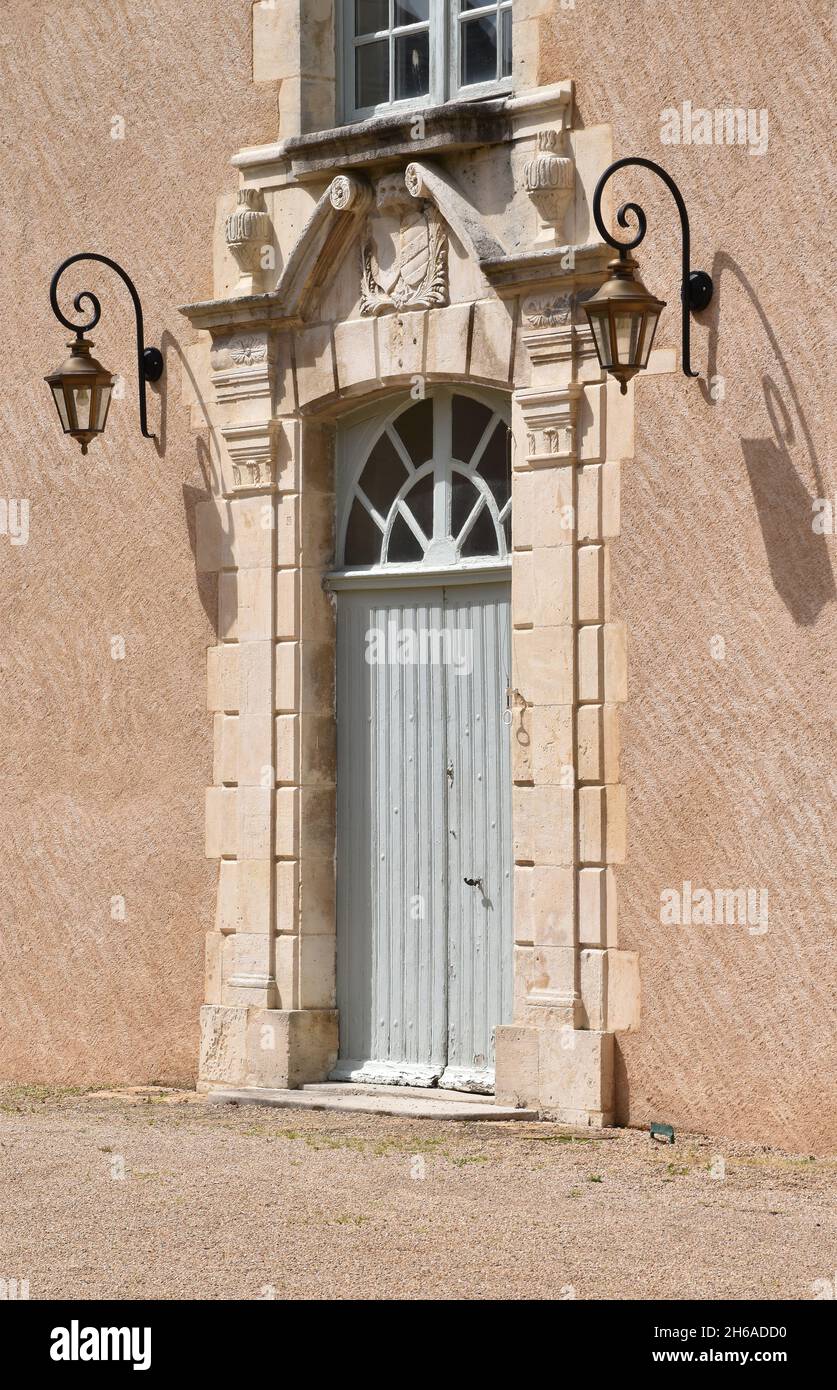 The main door to a Vieux Palais, small chateau in Montmorillon, France, with limestone outer frame with heavy rustication & Baroque broken pediment Stock Photo
