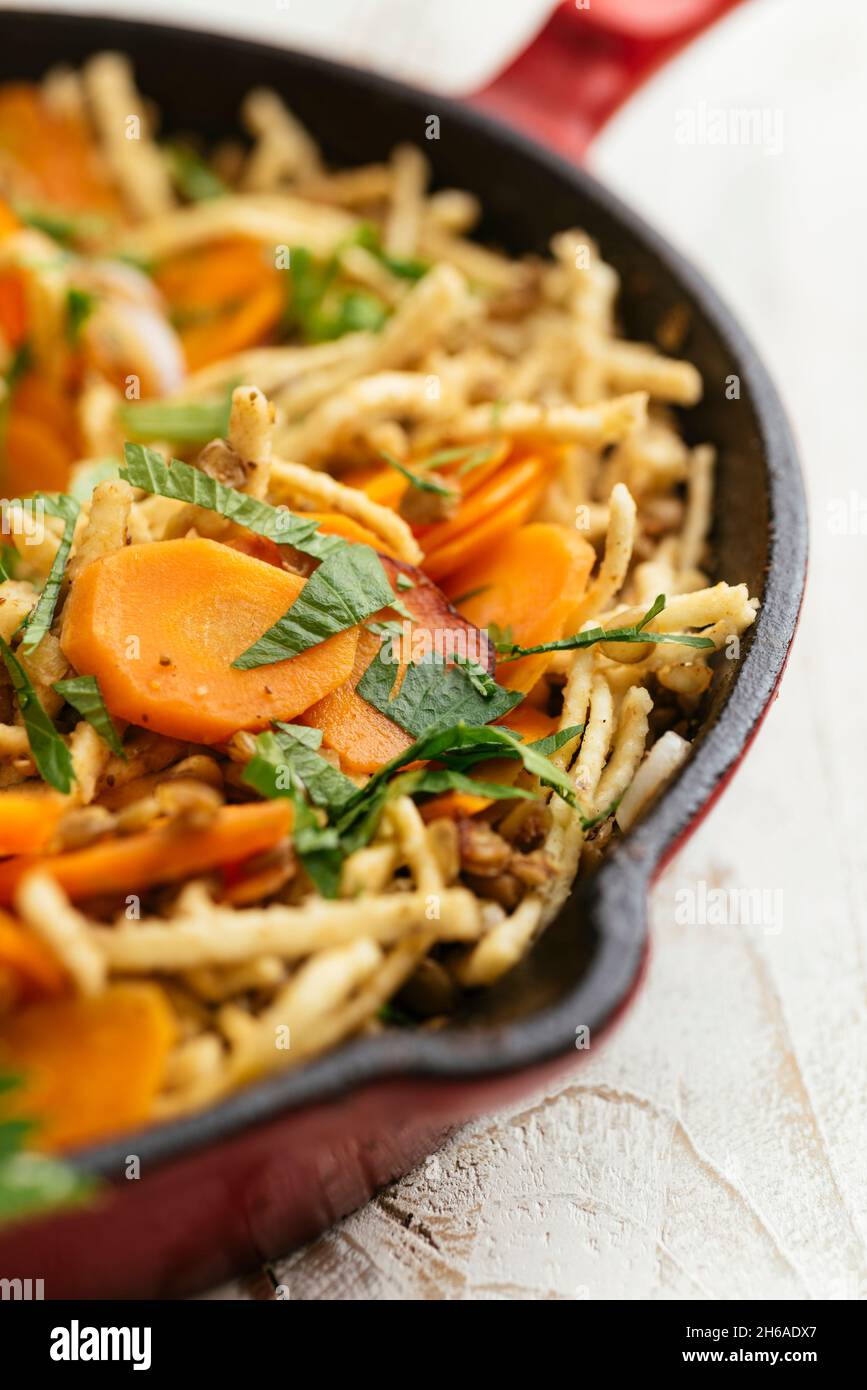 Skillet with lentils, carrots and Spätzle Stock Photo