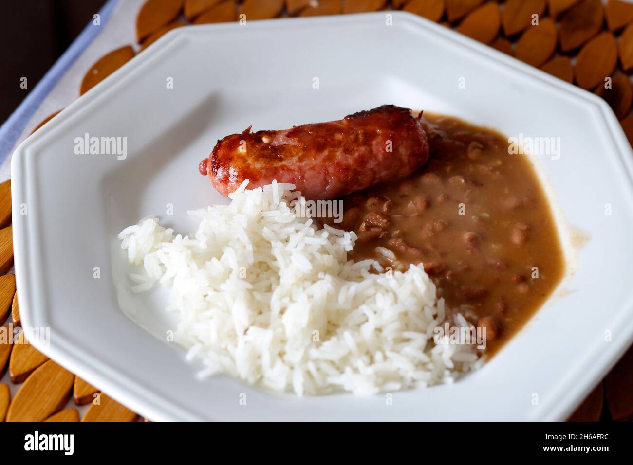 Ready-to-eat rice, beans and sausage on white plate Stock Photo