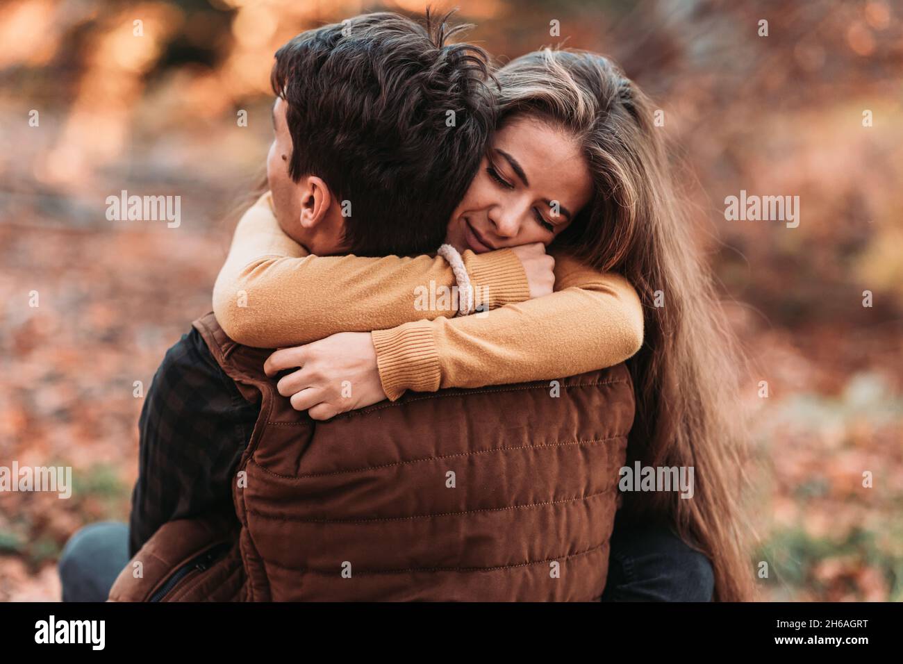 Young, romantic couple in a tight embrace in the woods. Autumn time Stock Photo