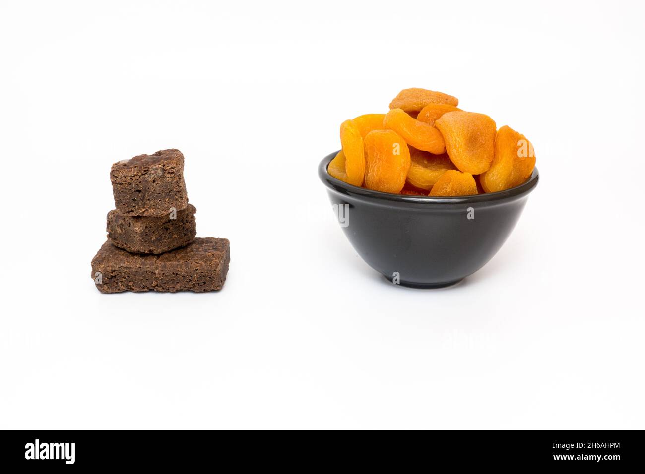 Healthy and Unhealthy sugary food concept with Dried Apricots and Sugary brownie mini bites on