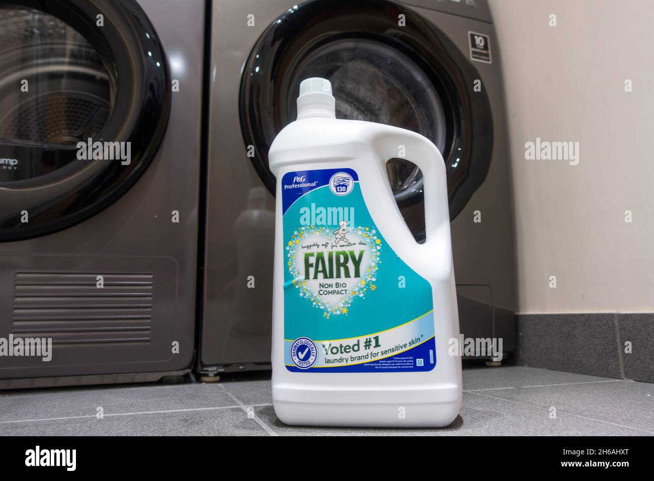 Fairy washing liquid bottle in front of a Washing machine in laundry room Stock Photo