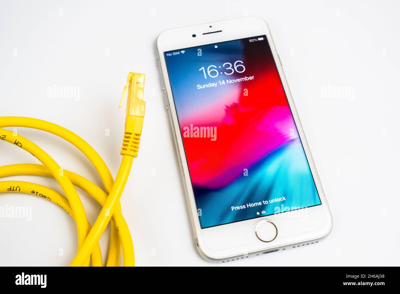 iPhone in white with a yellow LAN cable to indicate data speed concept
