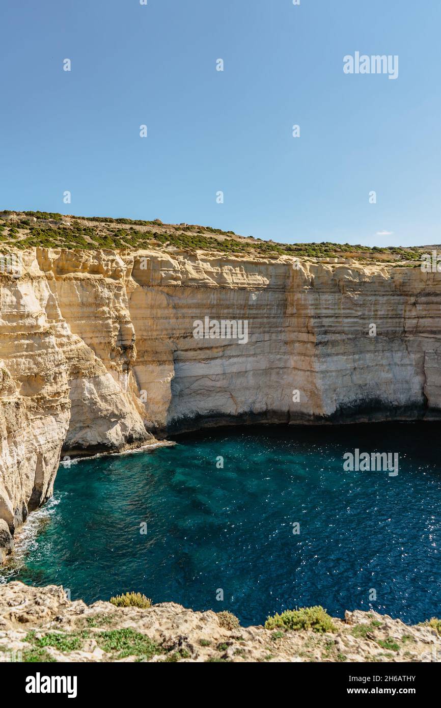 Rocky limestone coastline of Gozo island and Mediterranean Sea with turquoise blue water and caves.Great spot for hiking along Maltese coast.Popular w Stock Photo