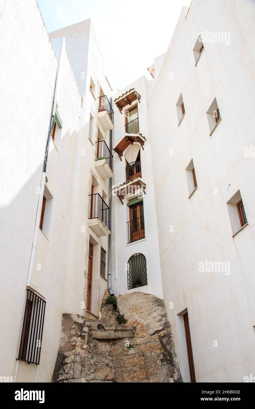 A low angle shot of a damaged apartment building with white exterior
