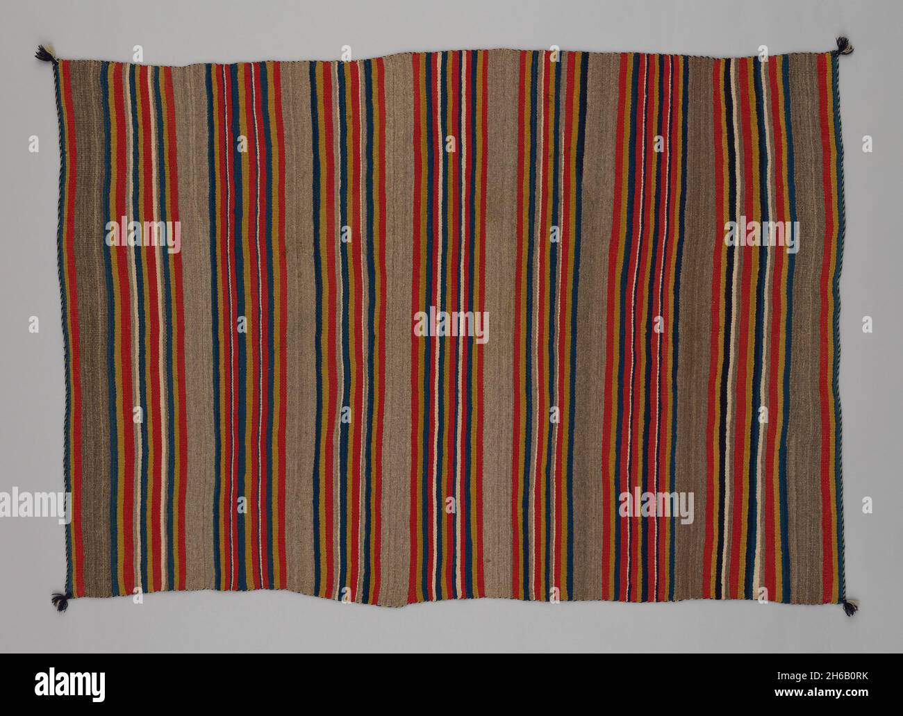 Shoulder Blanket with Plain-Stripe Design, 1860/90. A work made of wool, plain weave with &quot;lazy lines&quot; and dovetail tapestry weave; twined warp ends and selvages; knotted corner tassels. Stock Photo