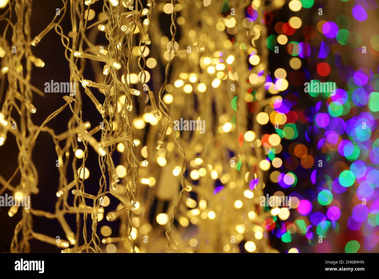 Christmas lights on electric garlands. Colorful New Year decorations, festive illumination in city Stock Photo