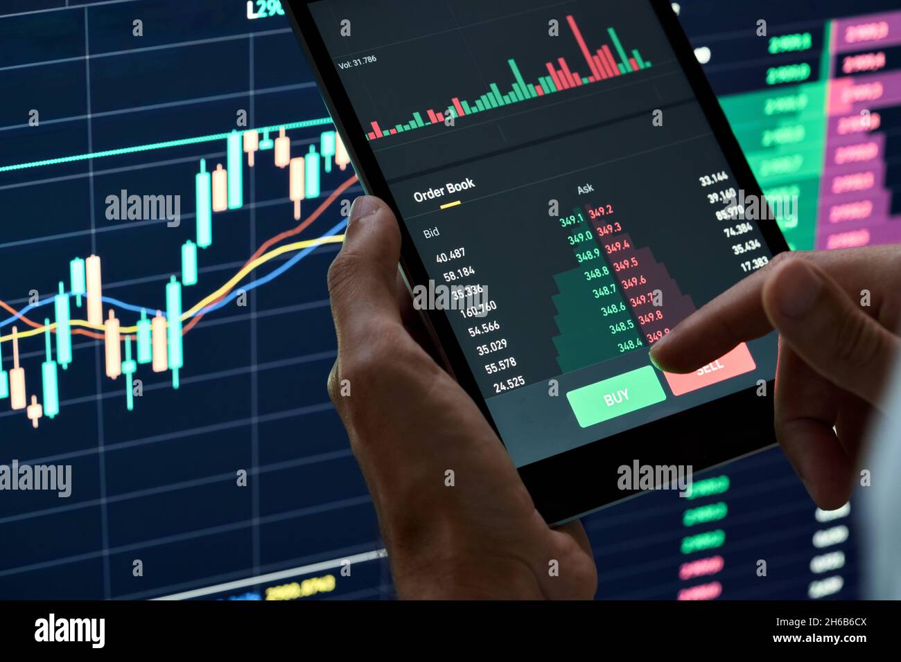 Crypto investor holding finger on buy sell button executing stock trading order. Stock Photo