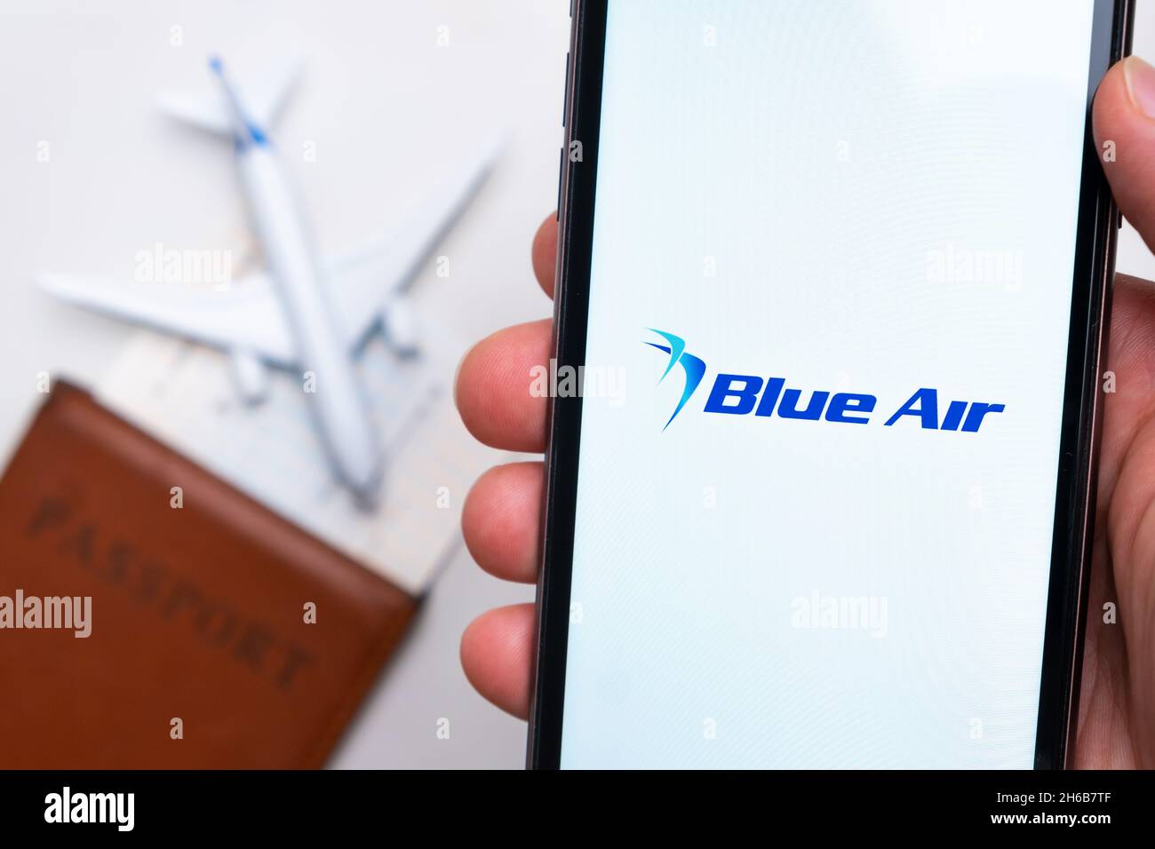 Blue Air airlines company app or logo displayed on a mobile phone with passport, boarding pass, and plane on the background, September 2021, San Francisco, USA.  Stock Photo