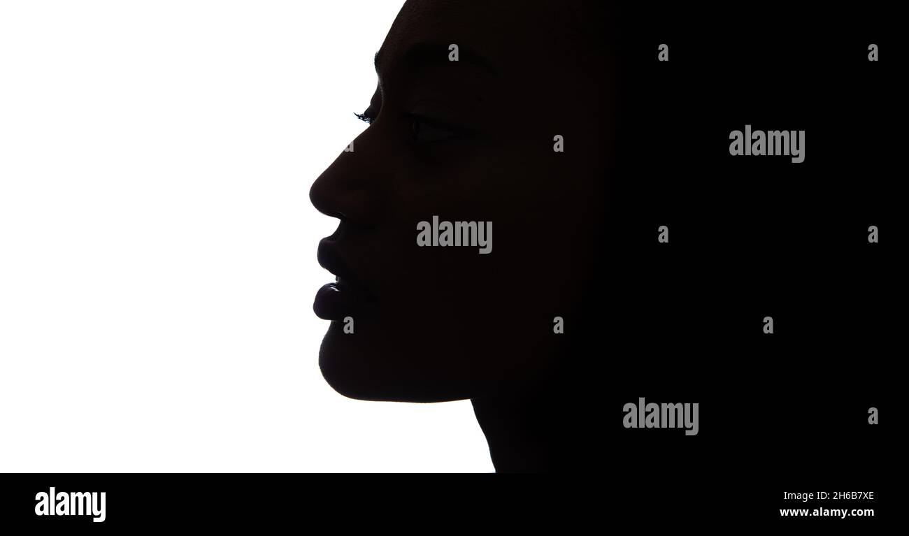 Black profile of an African woman on a white background, shaded silhouette of head. Proud woman face. Stock Photo