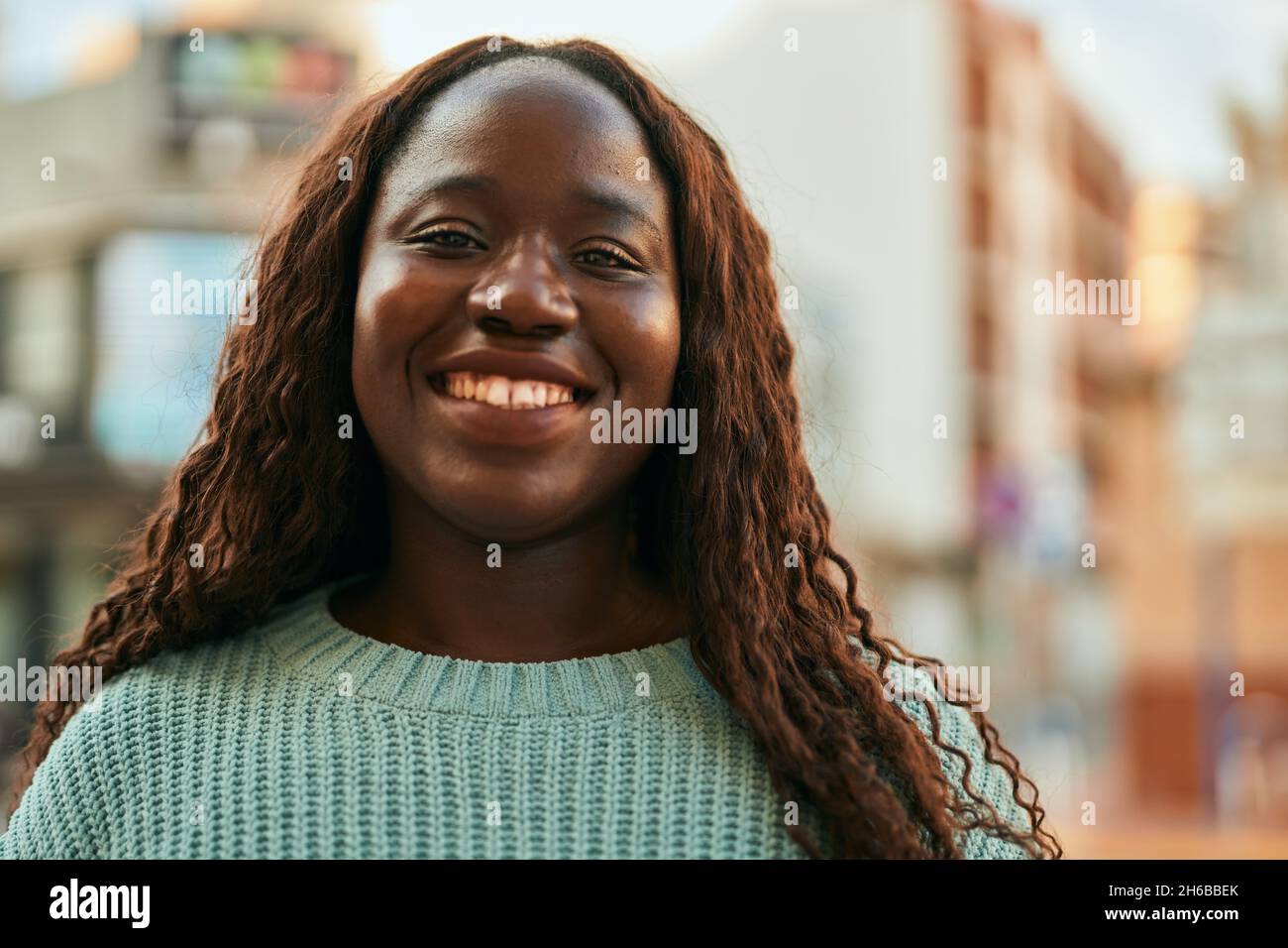 Young african woman smiling happy at the city Stock Photo - Alamy
