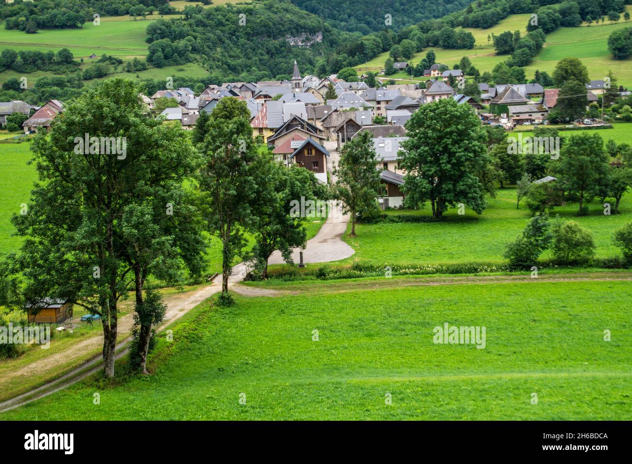 A beautiful view of a cute village with a lot of green trees on a sunny ...