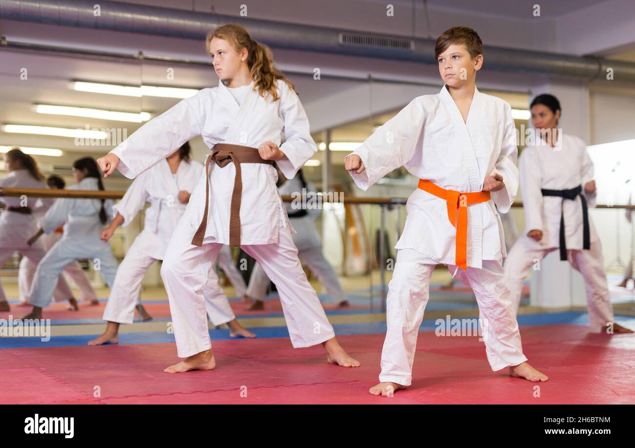 Teenager children wearing karate uniform fighters poses Stock Photo