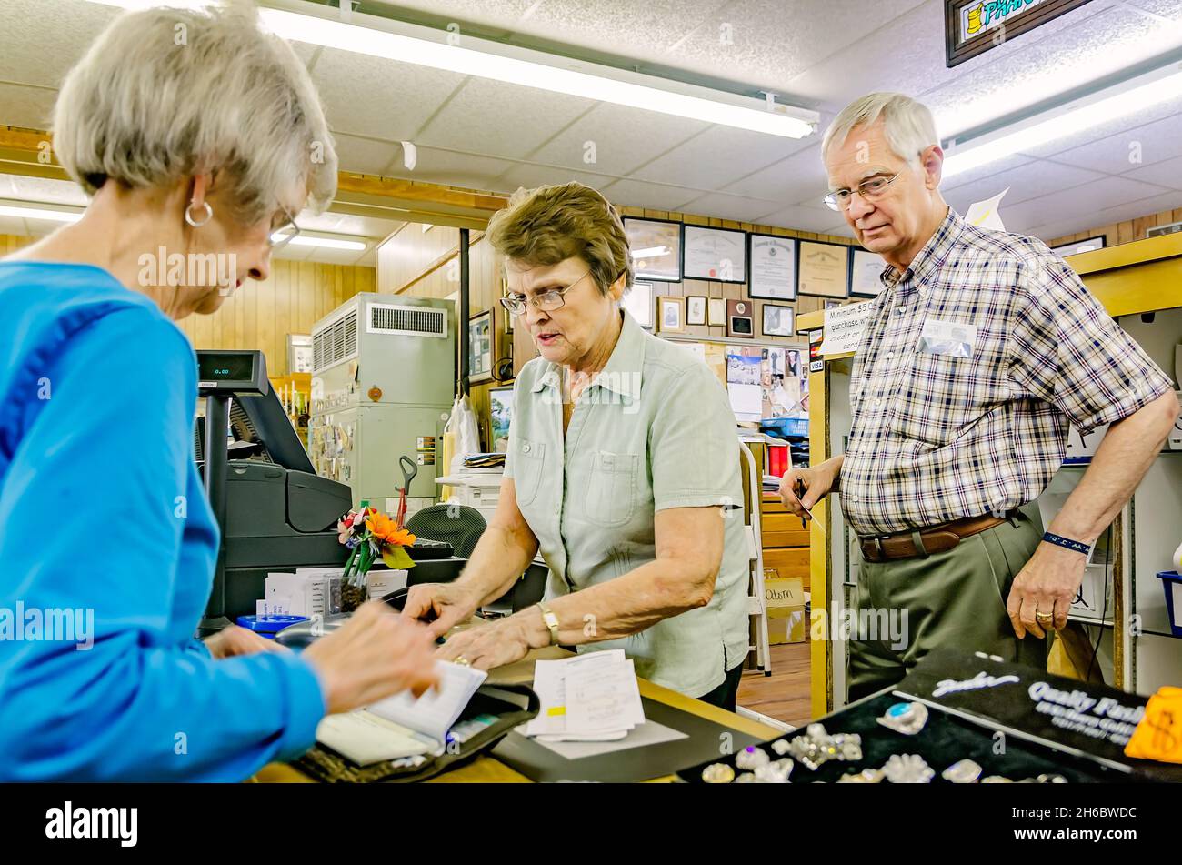 Pharmacist Robert Turnage watches as his wife, Monica, helps a customer at Turnage Drug Store in Water Valley, Mississippi. Stock Photo