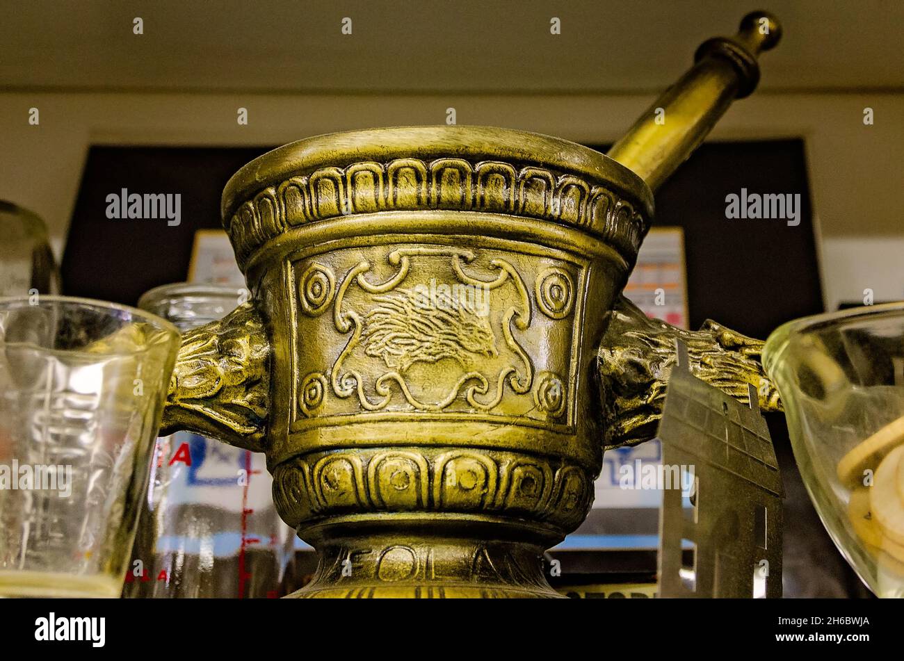 A vintage mortar and pestle is displayed alongside vintage glass