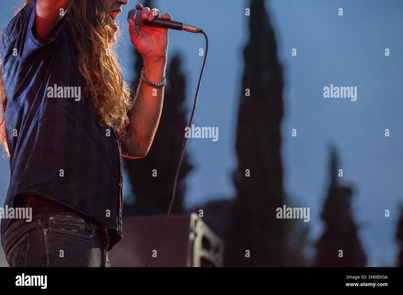 Hard rock singer performing. Blue sunset background Stock Photo