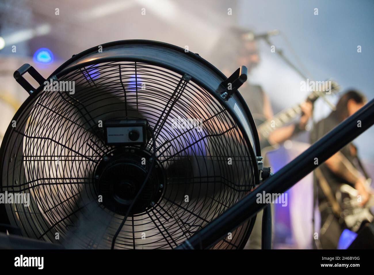 Stage blower used with haze machine during live rock performance. Musicians on background Stock Photo