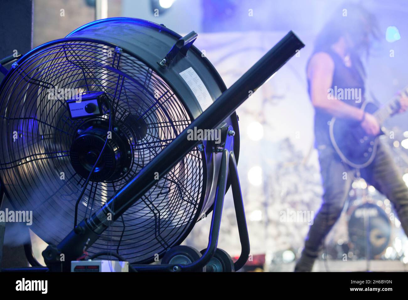 Stage blower used with haze machine during live rock performance. Musicians on background Stock Photo