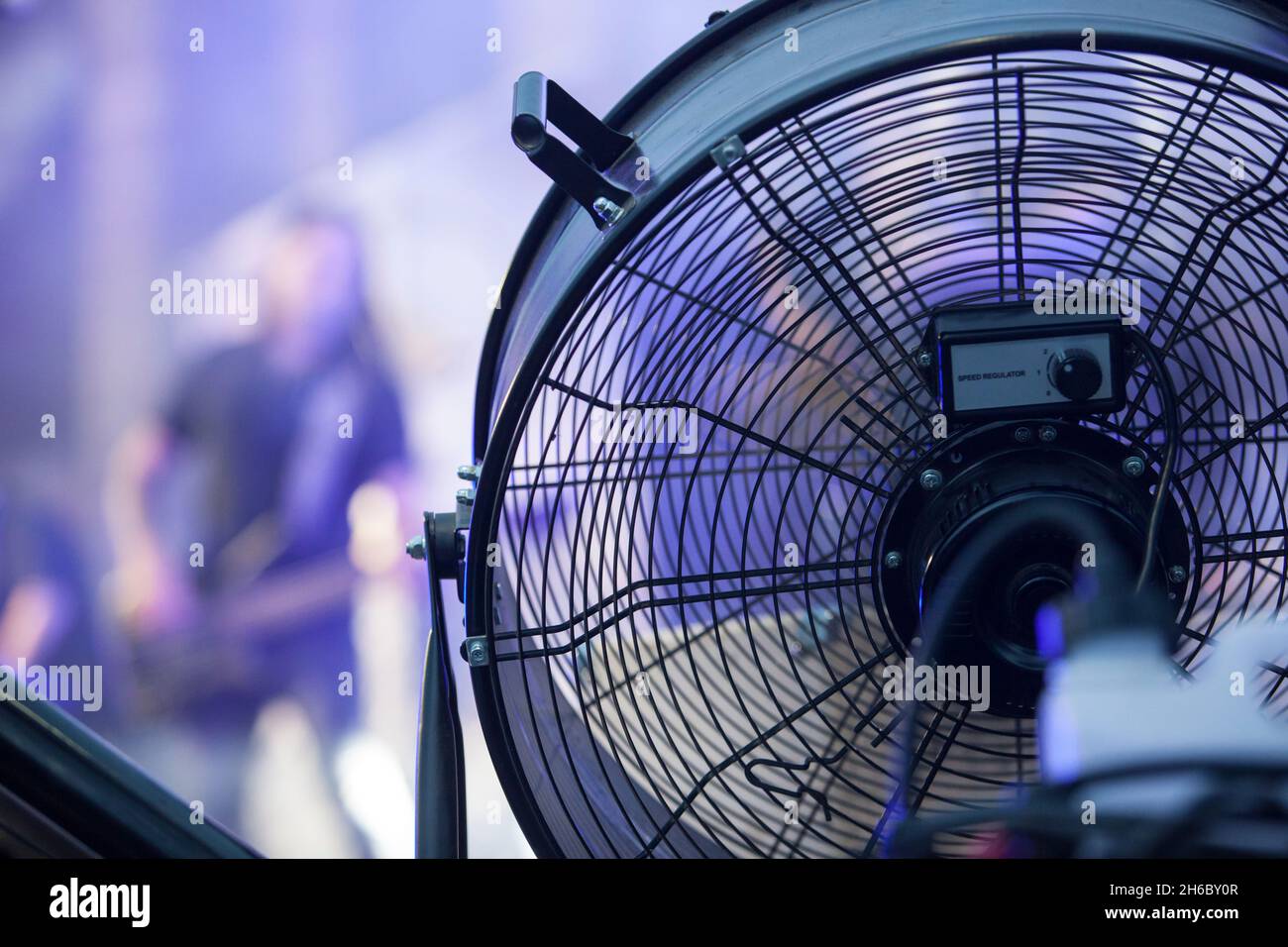 Stage blower used with haze machine during live rock performance. Musicians on background Stock Photo